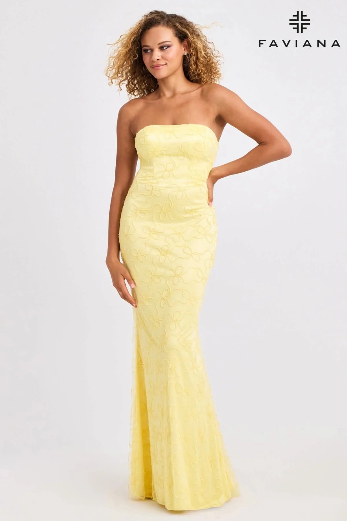 Woman wearing a yellow strapless gown with Faviana branding on a white background