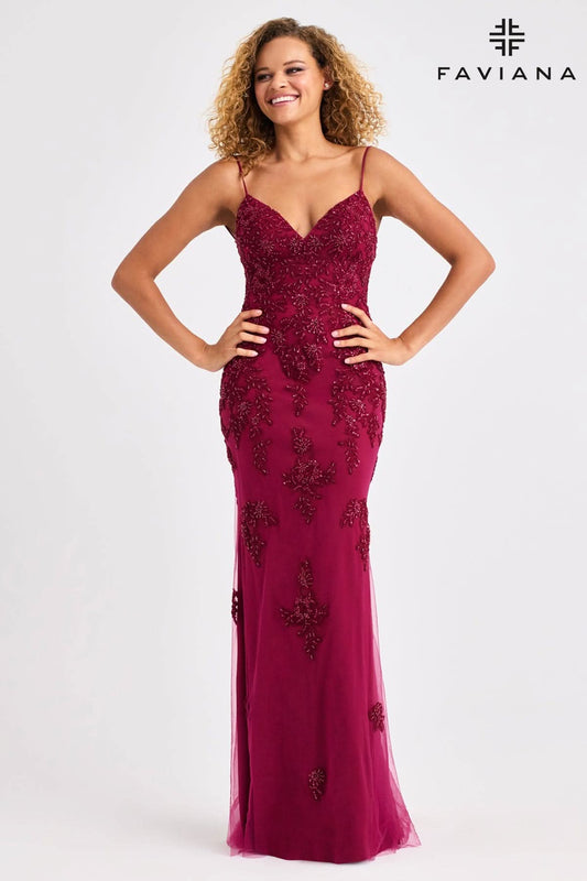 Woman wearing a burgundy evening gown with floral embellishments on a white background, branded 'Faviana'.