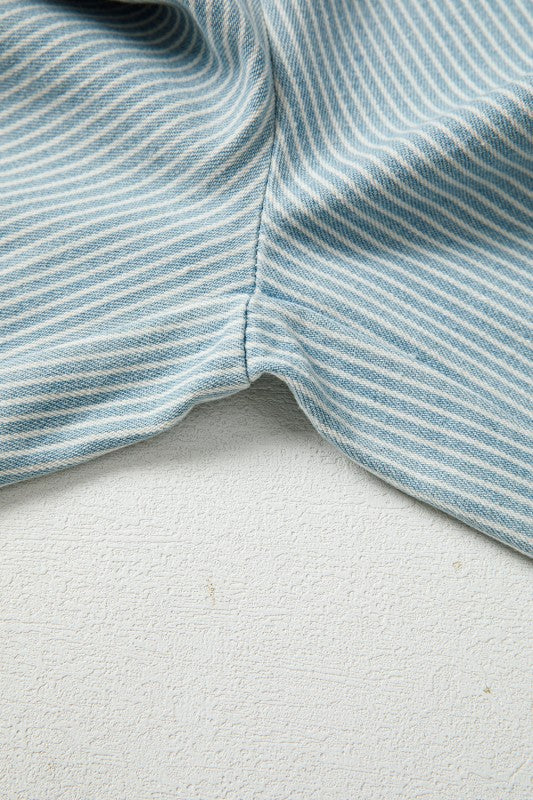 Close-up of blue and white striped fabric on a textured white surface
