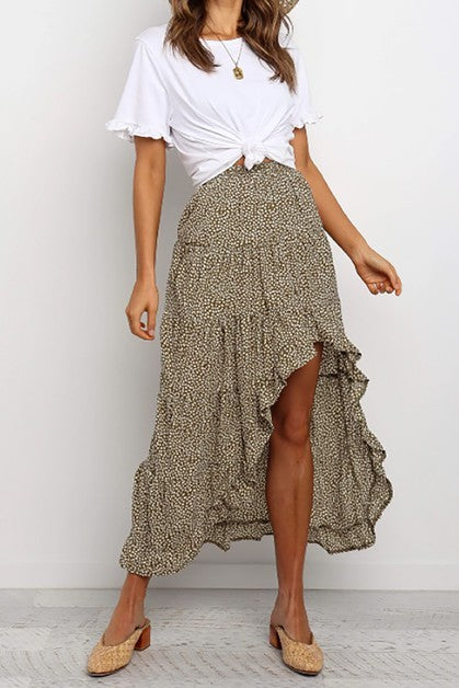 Woman wearing a white top and patterned skirt on a plain background