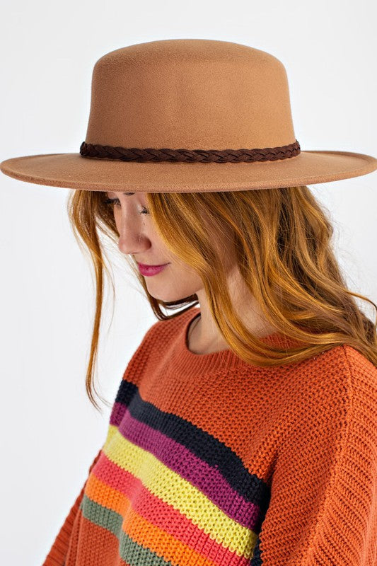 Person wearing a brown hat and colorful sweater on a white background