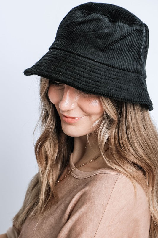 Person wearing a black bucket hat against a plain background