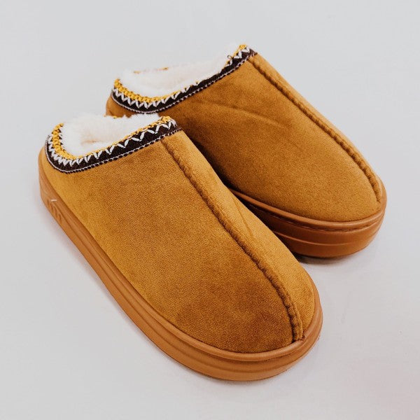Pair of brown slippers with white lining on a light gray background