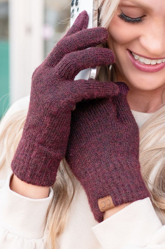 Person wearing maroon gloves with a blurred background