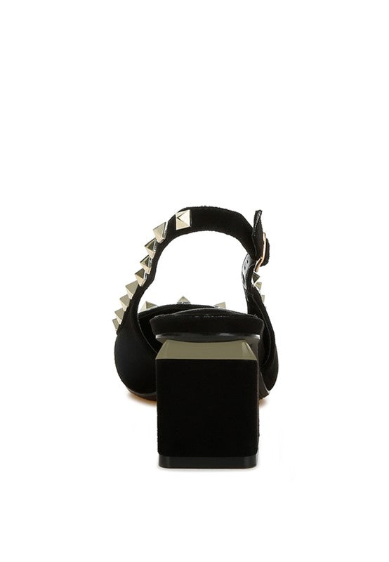 Black high-heeled shoe with studded details on a white background