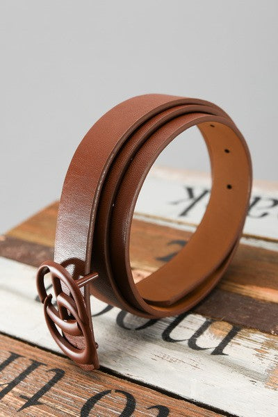 Brown leather belt with decorative buckle on a wooden surface