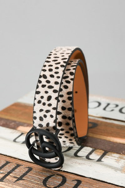 Leopard print belt with black buckle on a wooden surface