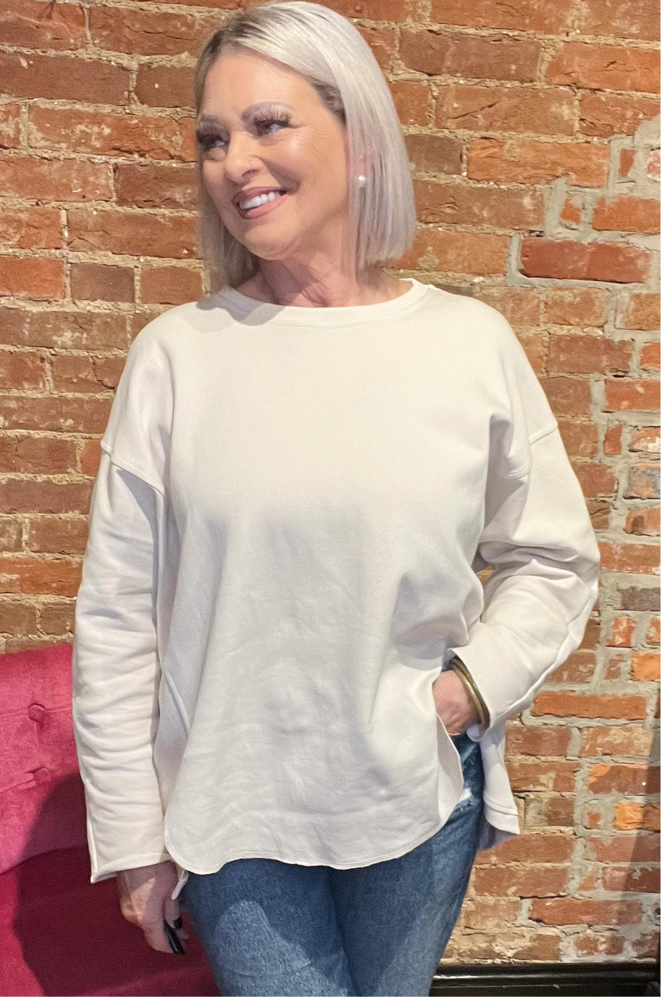 Woman wearing a cream-colored long sleeve pullover sweater