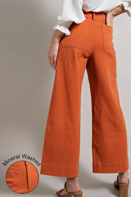 Orange wide-leg pants worn by a person on a plain background