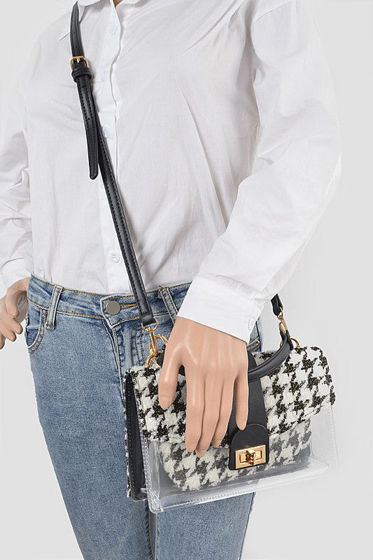 Person holding a patterned handbag with a white shirt and jeans on a plain background