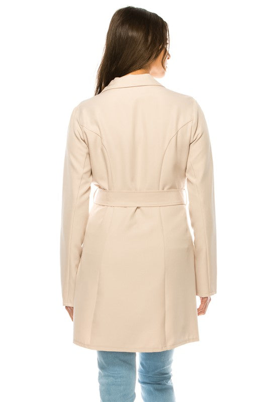 Woman wearing a beige trench coat on a white background