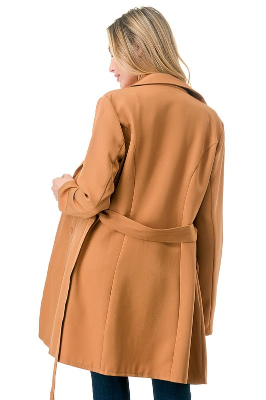 Woman wearing a tan coat on a white background