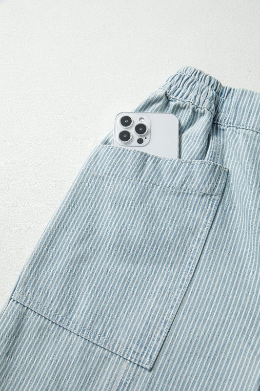 Light blue striped pants with a smartphone in the pocket on a light gray background