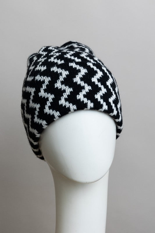 Black and white patterned knitted hat on a mannequin head against a gray background