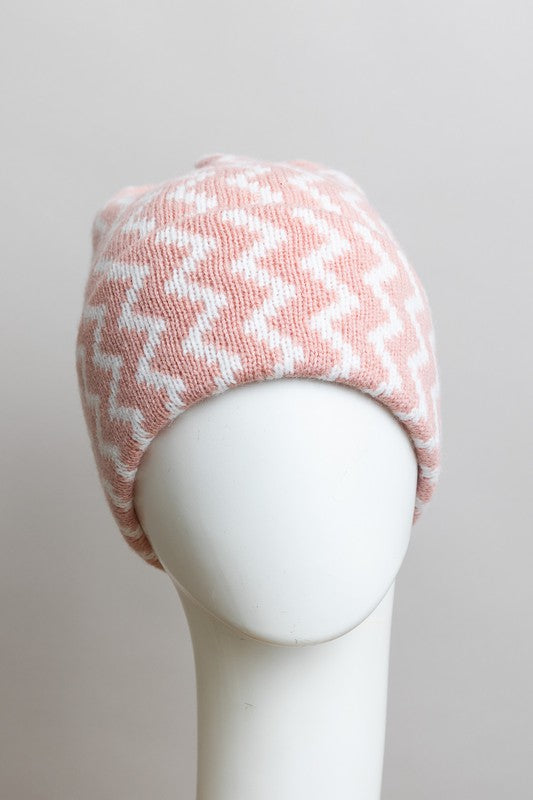 Pink and white patterned knit beanie on a mannequin head against a plain background