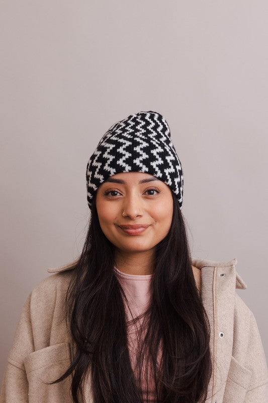 Woman wearing a black and white patterned beanie against a plain background