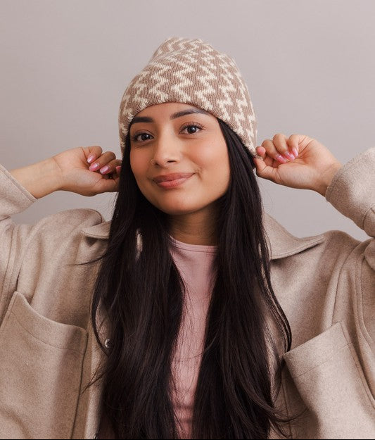 Woman wearing a patterned beanie against a plain background