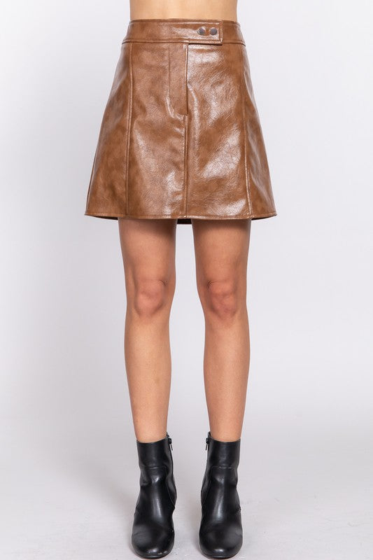 Brown leather skirt worn by a person on a white background