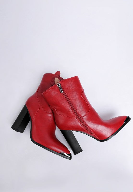Red ankle boots with black soles on a light gray background
