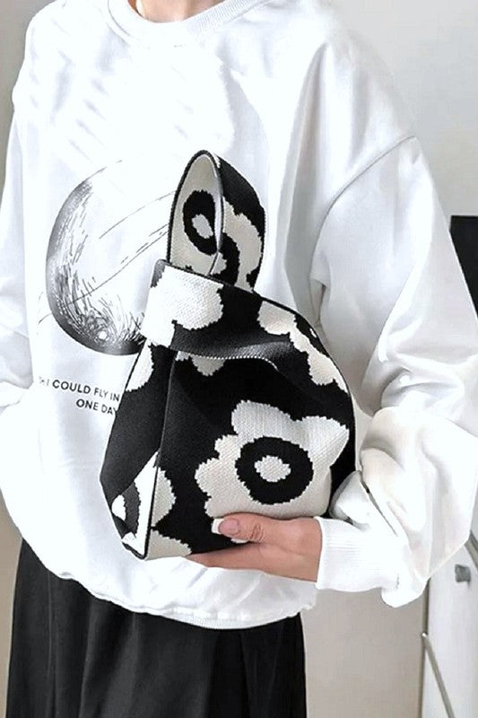 White sweatshirt with black and white abstract design held by a person