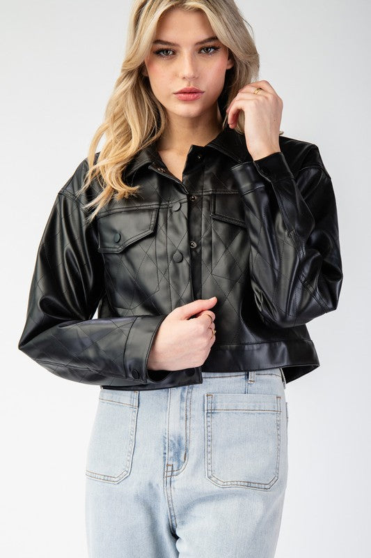 Woman wearing a black leather jacket and light blue jeans on a white background