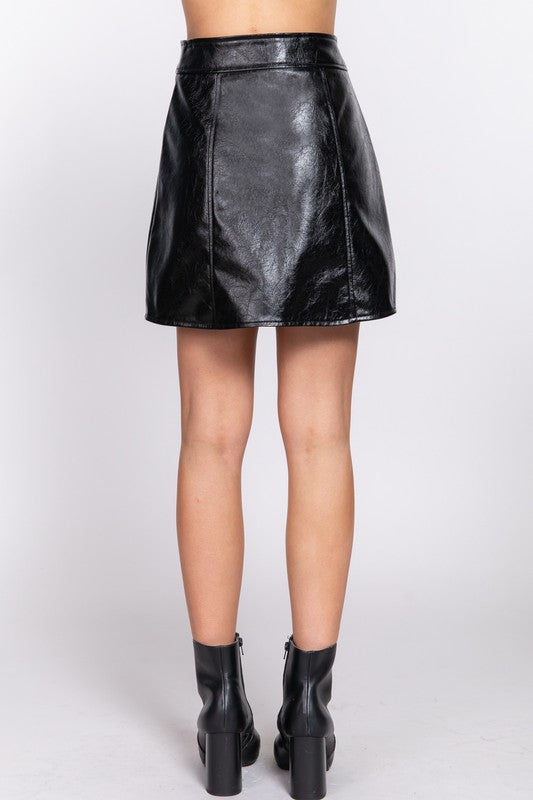 Black leather skirt worn by a person on a white background