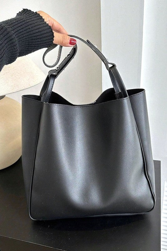 Black handbag on a black surface with a neutral background