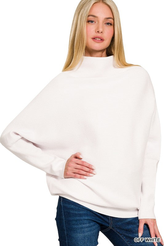 Woman wearing a white sweater and blue jeans on a white background
