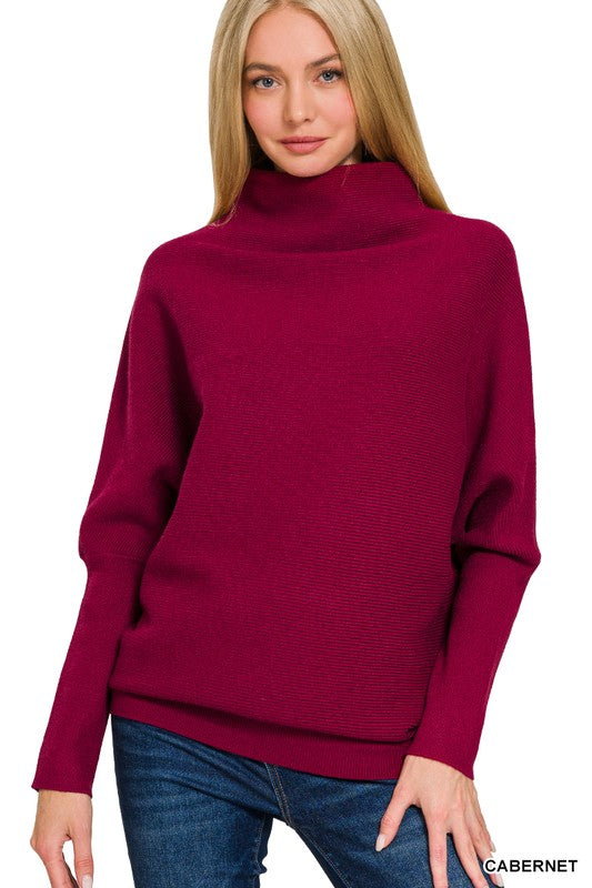 Woman wearing a maroon sweater with a plain background