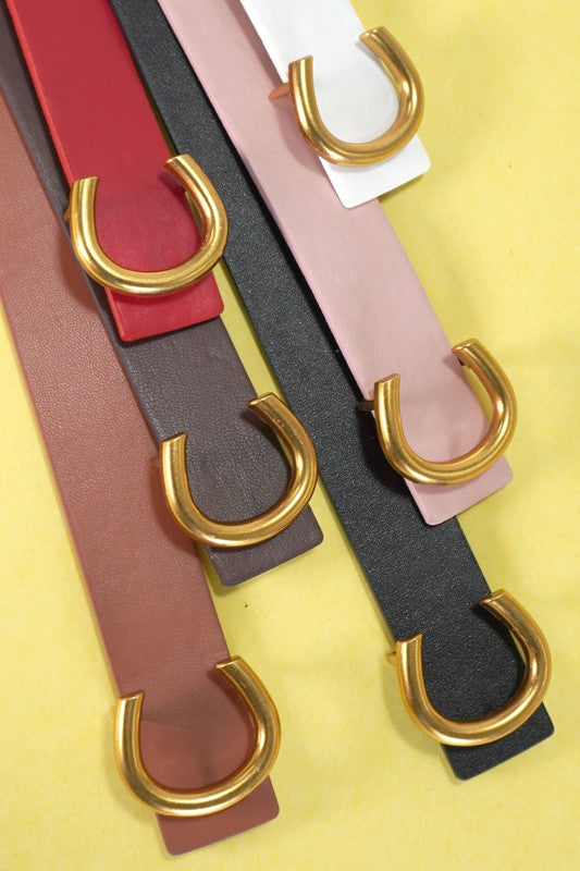Four belts with gold buckles on a yellow background