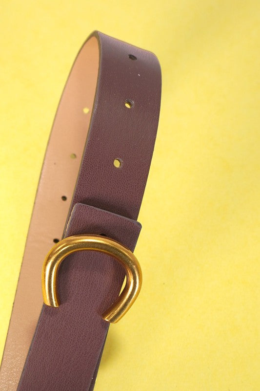 Brown leather belt with a gold buckle on a yellow background
