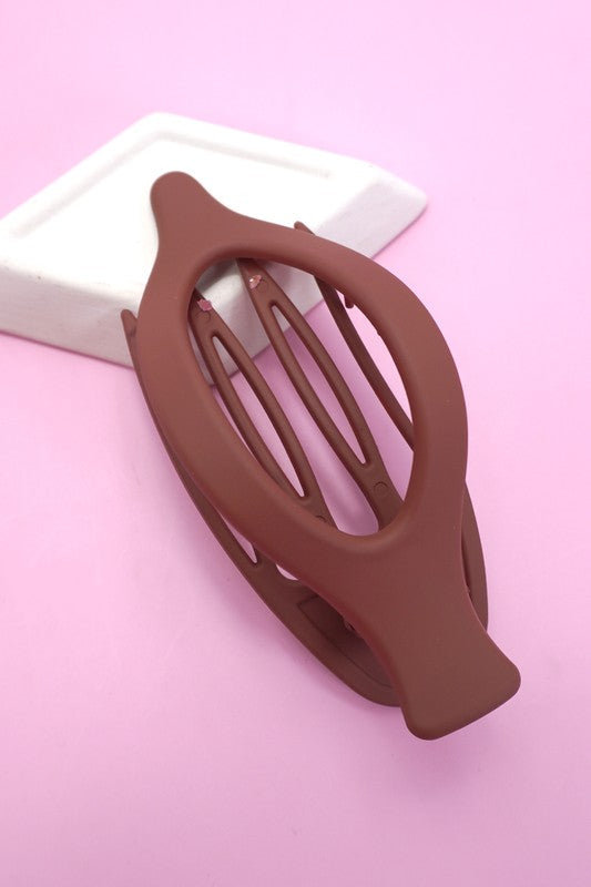 Brown hair clip on a pink background