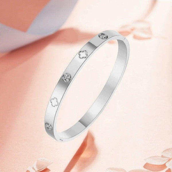Silver bracelet with diamond-like stones on a soft pink background