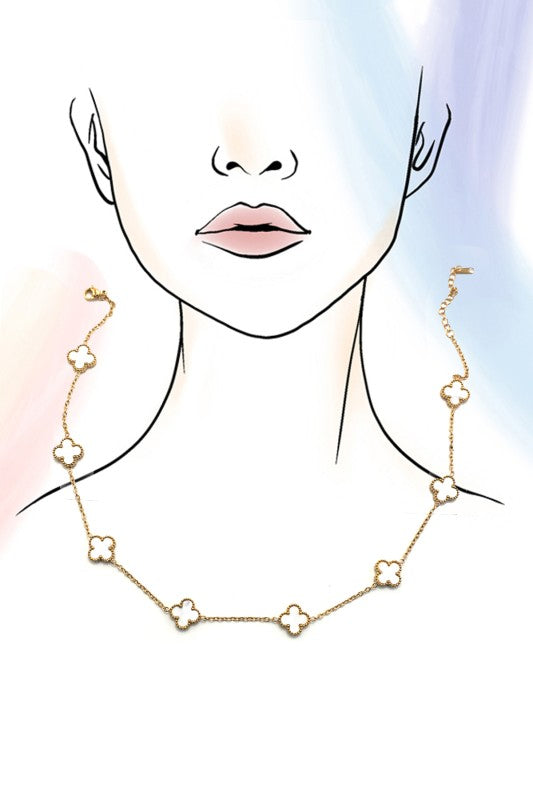 Gold necklace with floral designs worn by a person on a white background