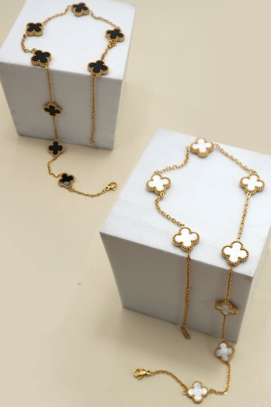 Gold necklaces with floral designs on white boxes