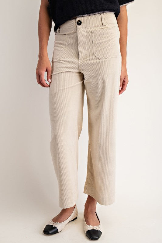 Person wearing beige wide-leg pants on a plain background