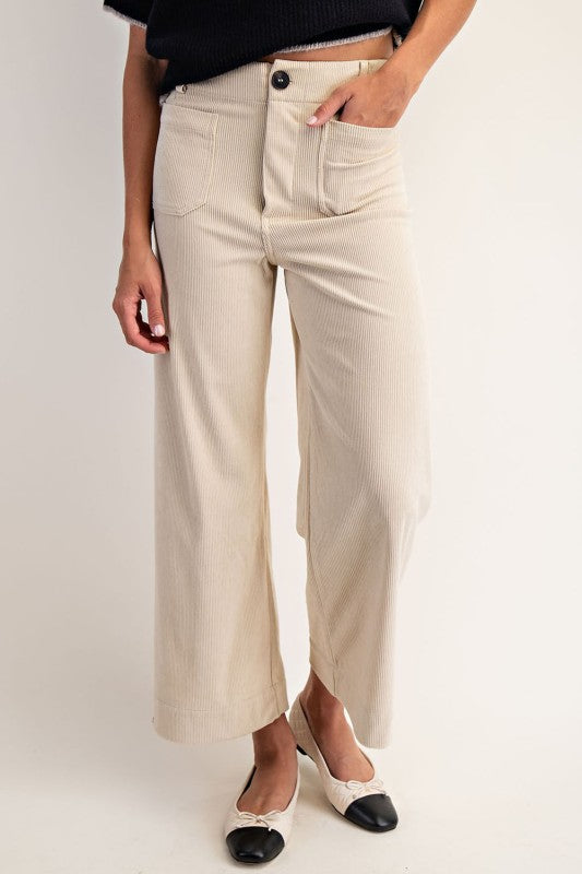 Person wearing beige wide-leg pants on a plain background