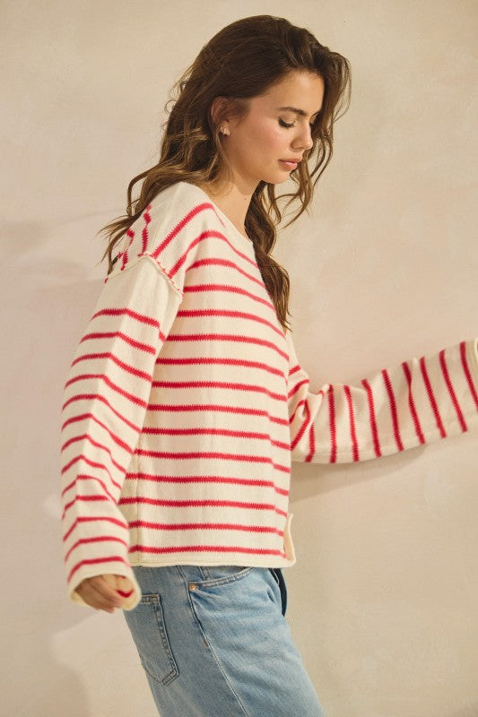 Woman wearing a red and white striped sweater with a beige background