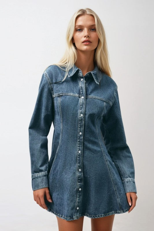 Woman wearing a denim dress against a plain background