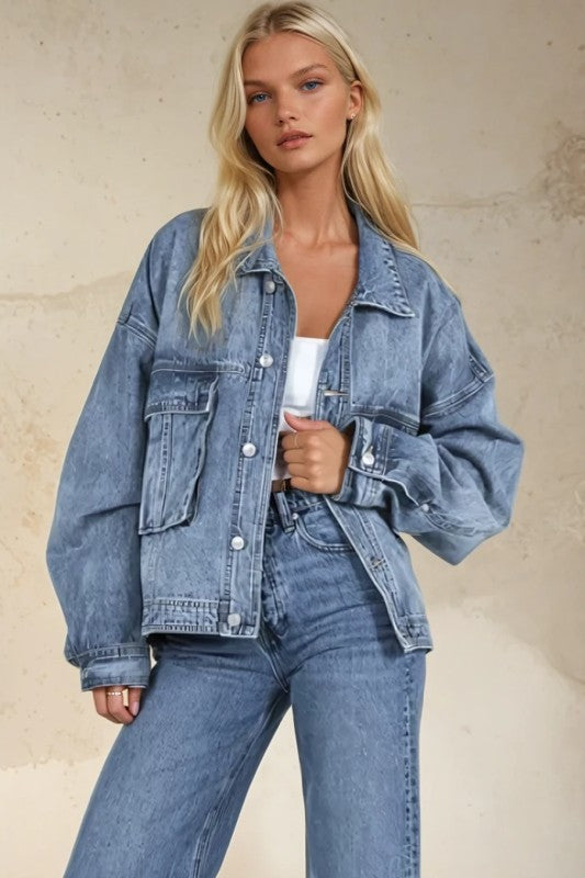 Woman wearing a denim jacket and jeans against a beige background