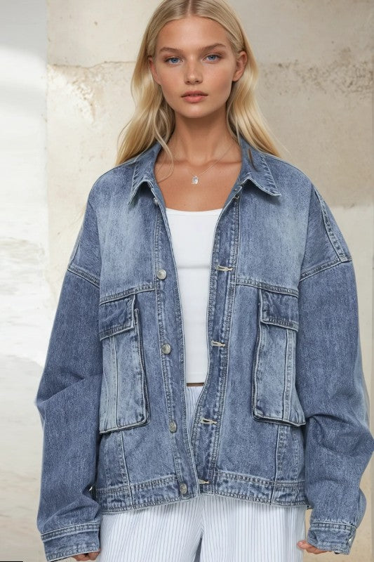 Woman wearing a blue denim jacket over a white top against a neutral background
