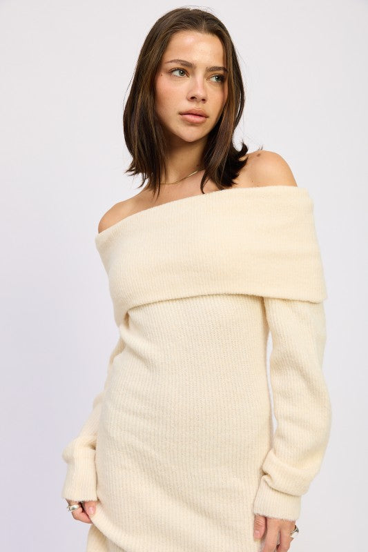 Woman wearing a beige off-shoulder sweater against a light gray background