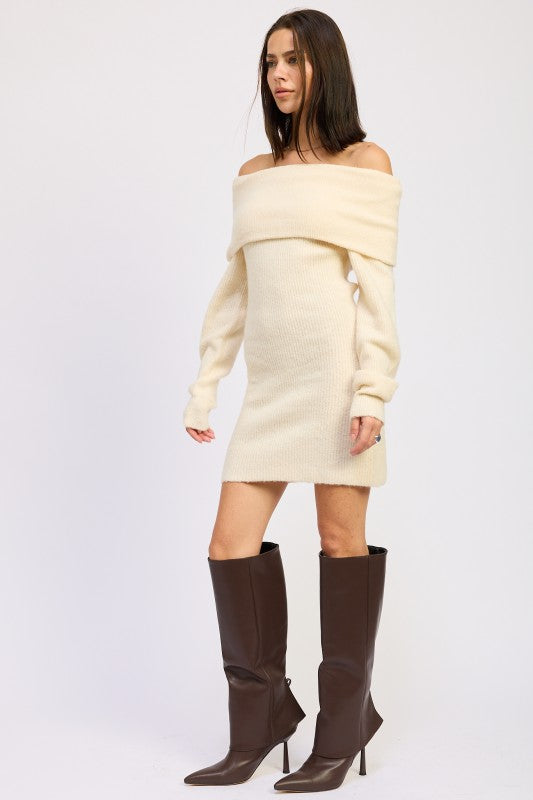 Woman wearing a cream off-shoulder sweater dress with brown knee-high boots on a white background