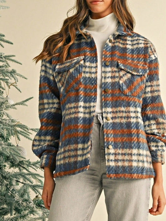 Person wearing a plaid jacket with a Christmas tree in the background