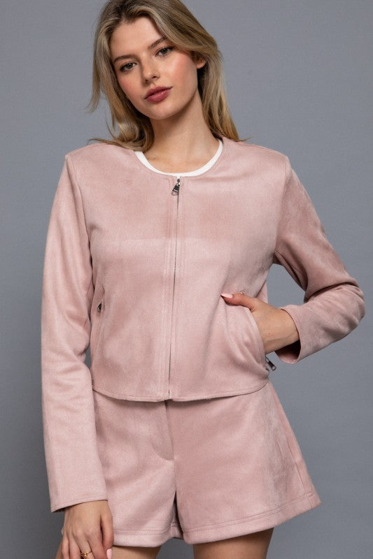 Woman wearing a pink tracksuit against a gray background