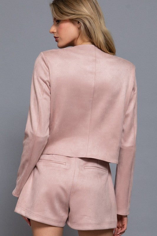 Woman wearing a pink outfit against a gray background