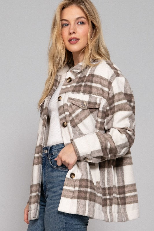 Woman wearing a plaid jacket on a gray background