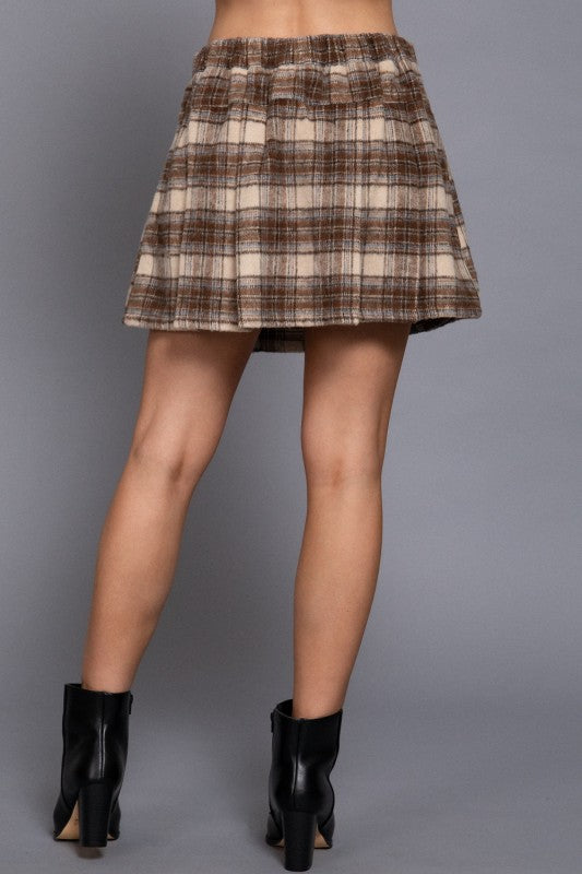 Plaid skirt worn by a person on a gray background