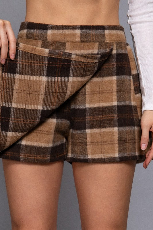 Plaid shorts worn by a person on a gray background
