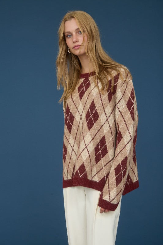 Woman wearing a patterned poncho against a blue background